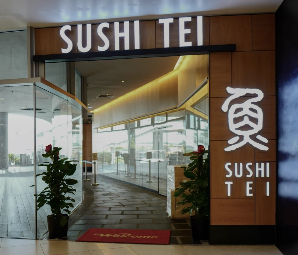 Sushi Tei restaurant entrance at VivoCity, with the illuminated sign above a glass-fronted walkway