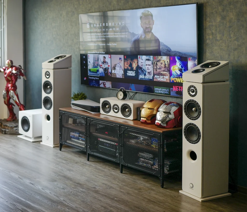 An Elipson Prestige Facet 5.1.2 home theatre system in white, arranged around a wall-mounted television in a living room.