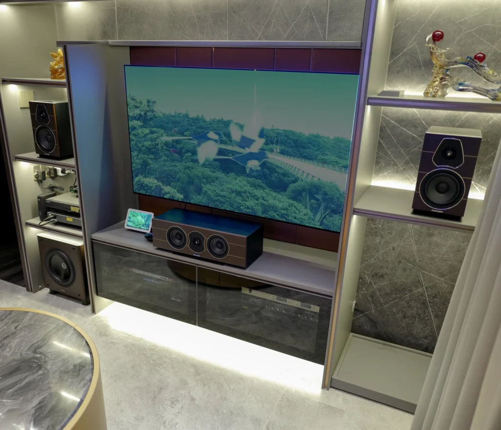 A Sonus Faber Lumina 5.1.4 home theatre built into a living room's joinery wall, with bookshelf speakers in lit niches either side of the television.