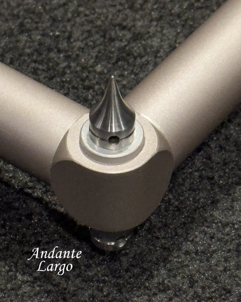 Spiked foot at the corner joint of an Andante Largo silver frame, resting on dark carpet.