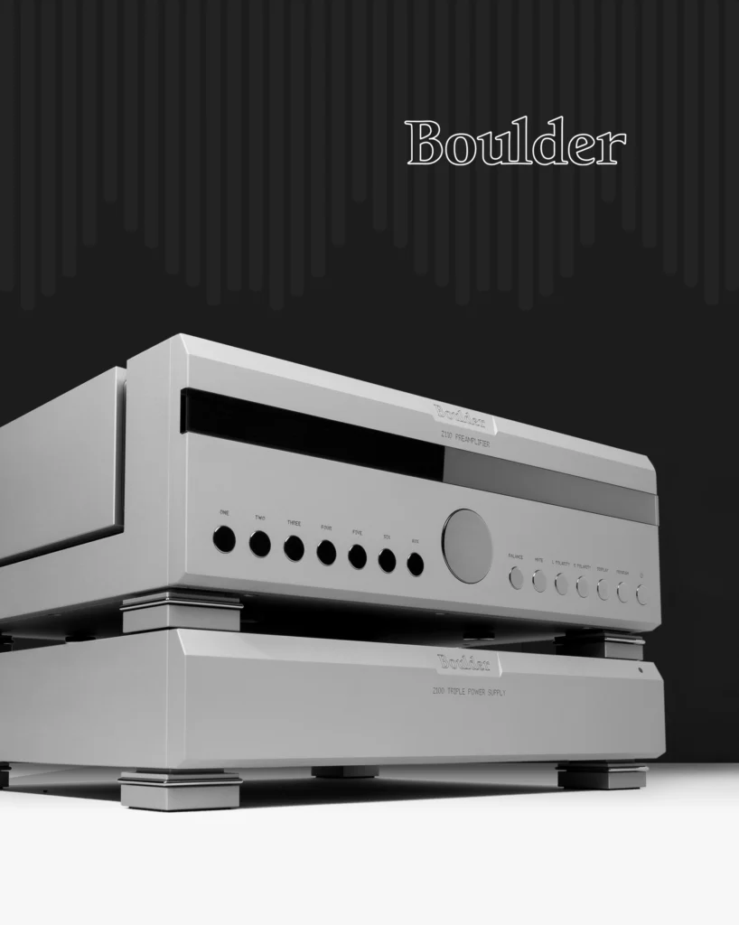 Boulder silver control unit stacked on a power amplifier, shown against a dark background with a pale floor.