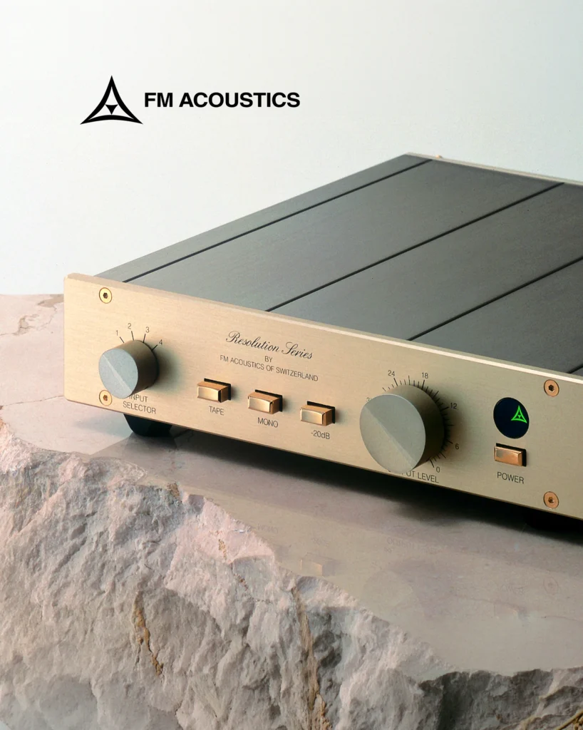 FM Acoustics Resolution Series preamplifier with a gold front panel, resting on a pale stone surface.