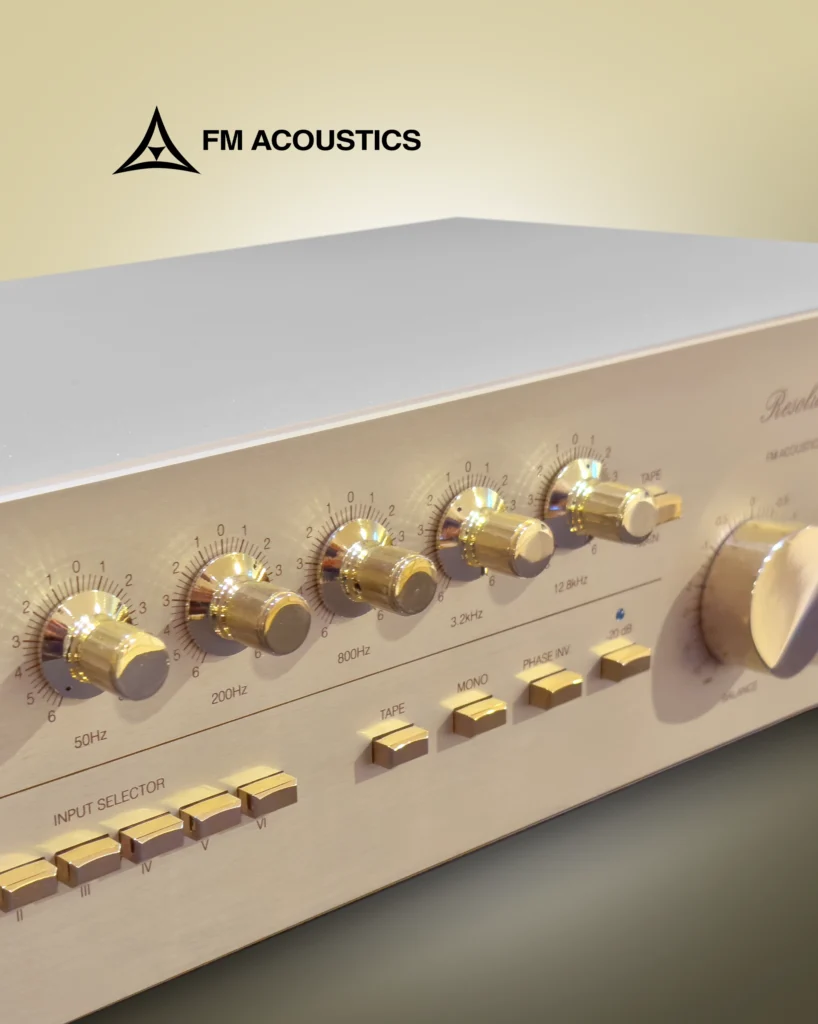 Close-up of an FM Acoustics Resolution Series front panel with gold rotary tone controls and input selector buttons.