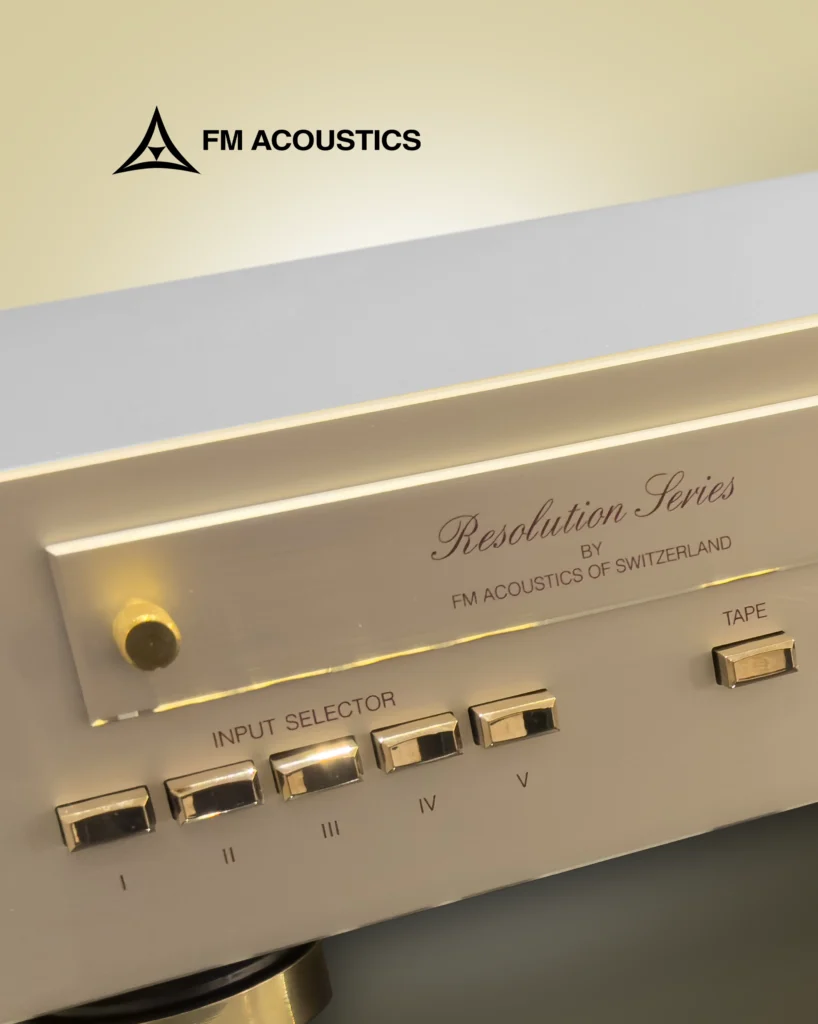 Close-up of an FM Acoustics Resolution Series front panel with gold input selector buttons and a tape button.