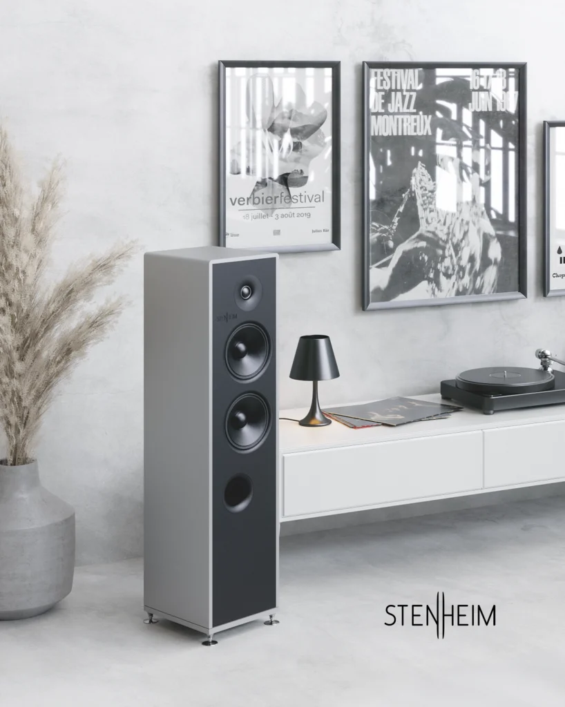 Stenheim floorstanding speaker with grey sides and a black front baffle beside a turntable on a white sideboard.