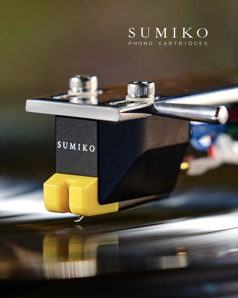 Sumiko phono cartridge with a yellow stylus housing above a record.