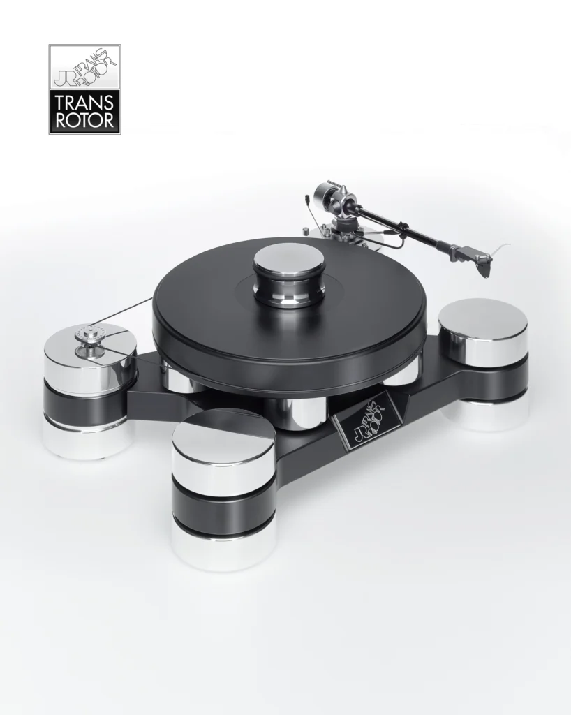 Transrotor turntable with a black platter, tonearm and chunky polished aluminium feet on a pale background.