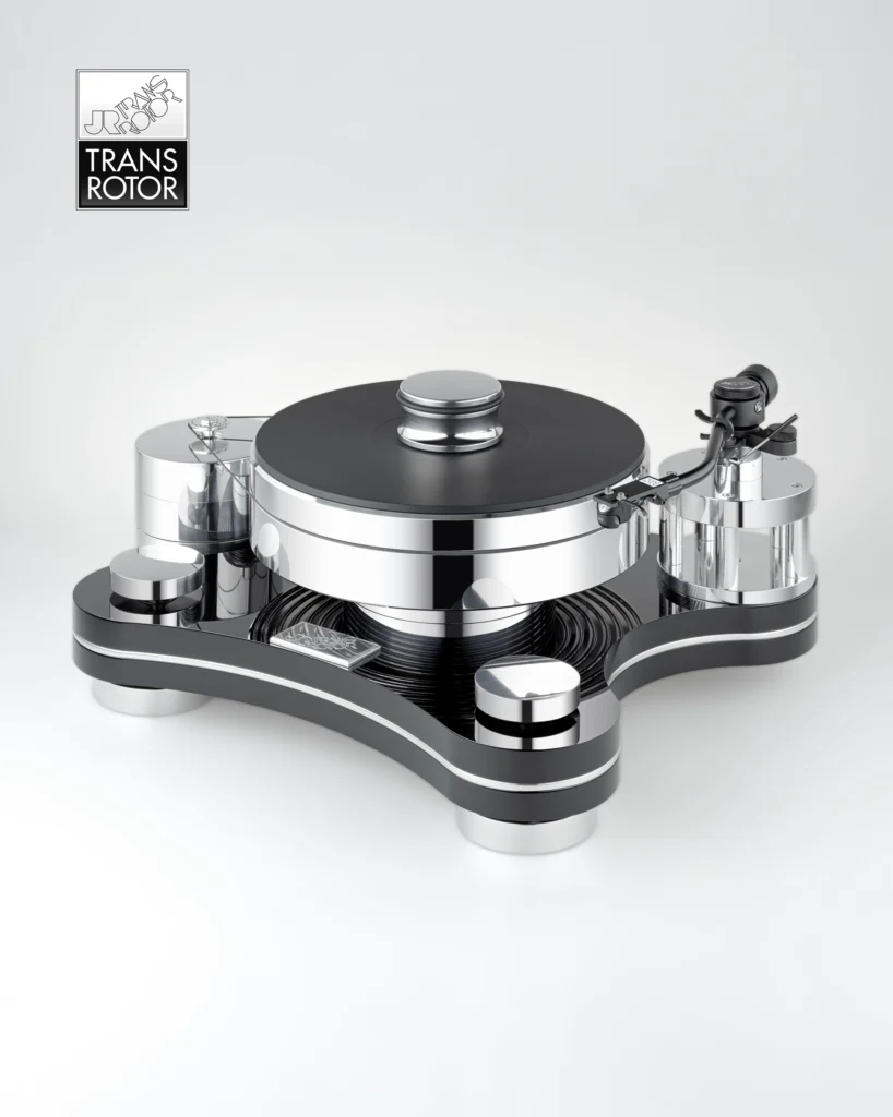Transrotor turntable with a black plinth, polished steel platter and tonearm on a pale background.