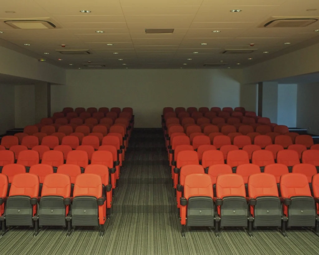 Rows of red theatre seats facing the front of the corporate function room