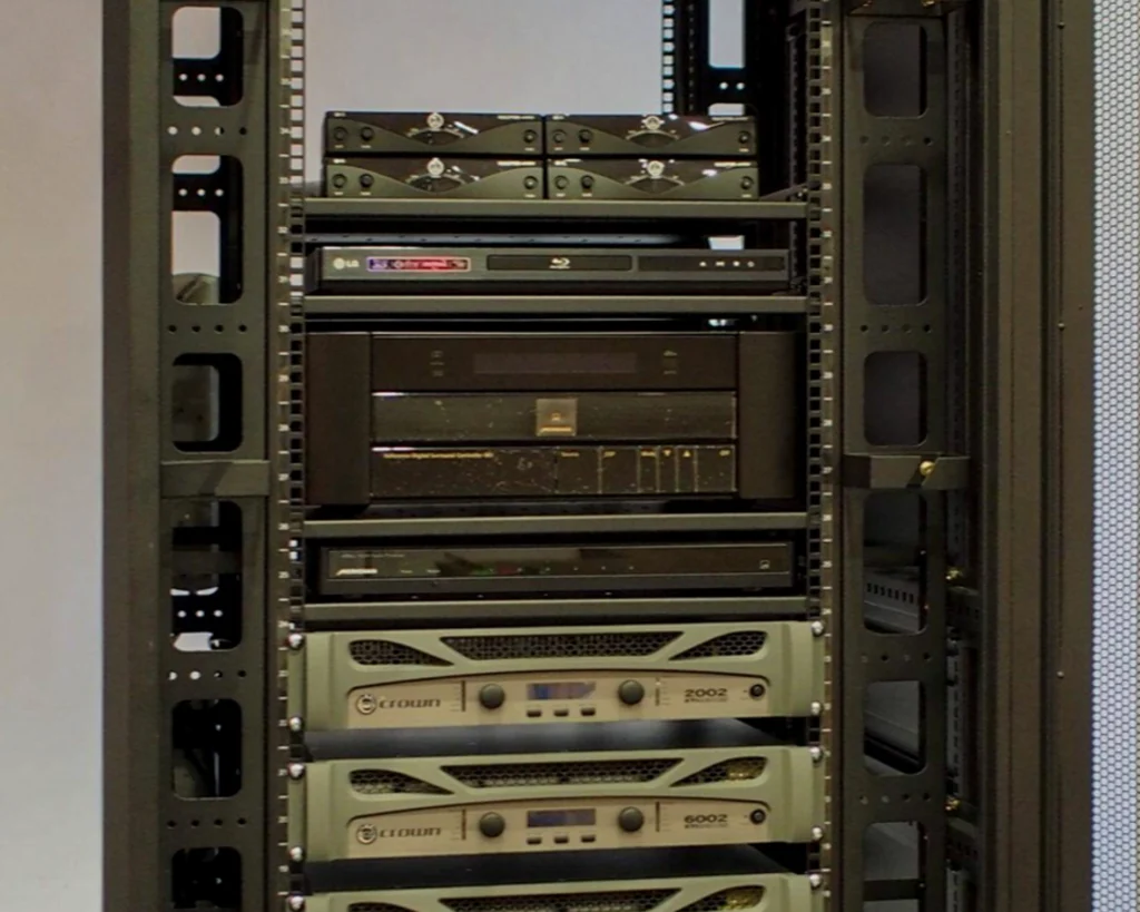 Equipment rack holding a Blu-ray player, a processor and power amplifiers for the function room and theatre