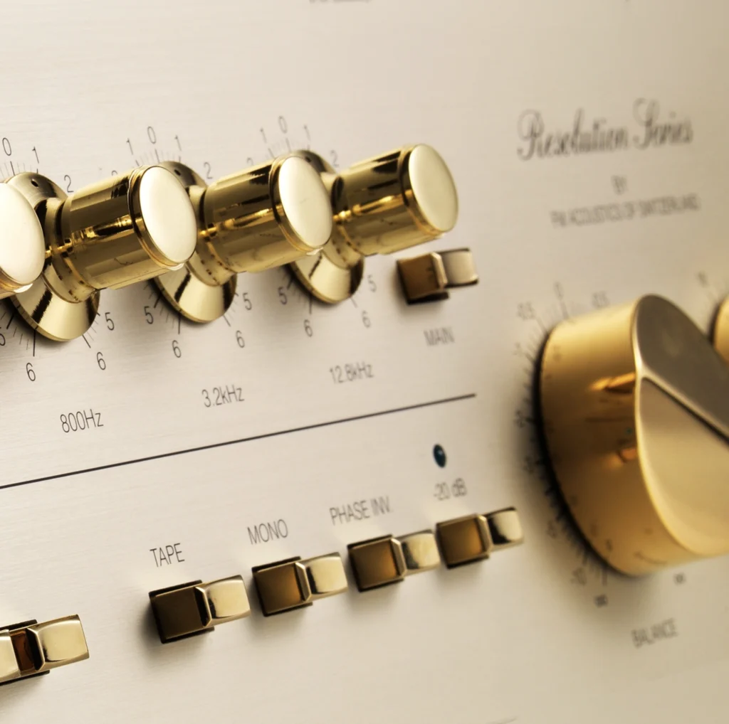 A close view of an FM Acoustics Resolution Series preamplifier front panel, with gold level knobs and frequency controls on brushed champagne.