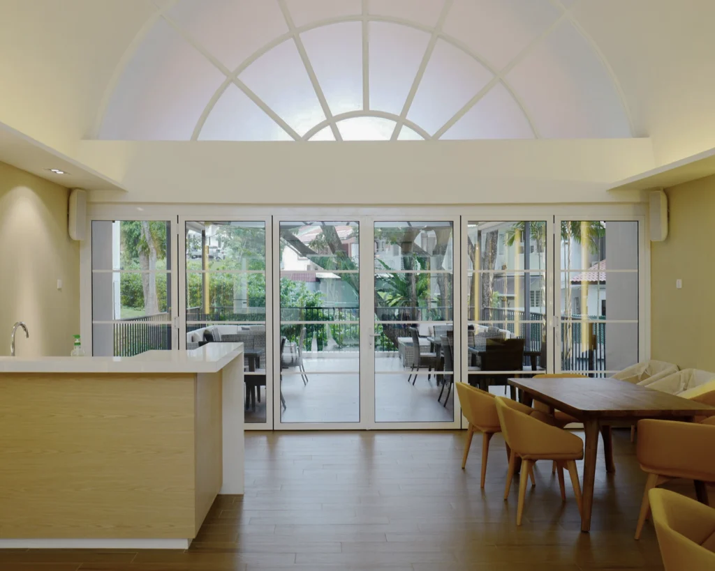 Clubhouse kitchen counter and dining area, with a speaker mounted on the wall beside the glass doors