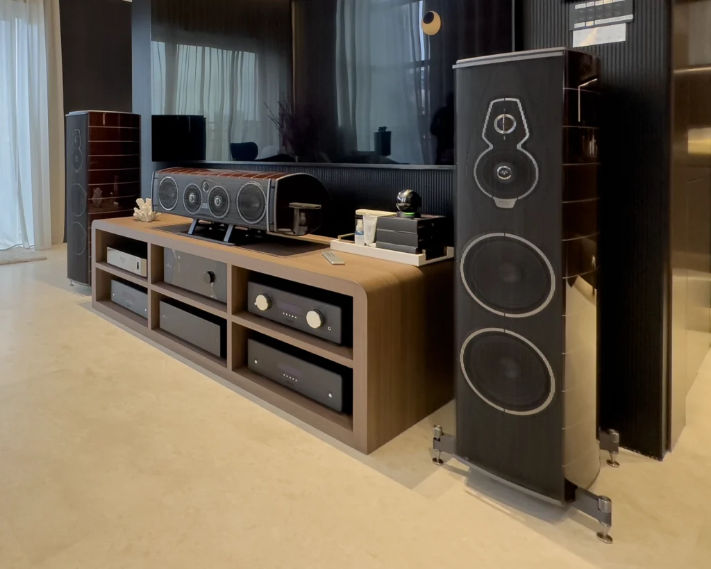 Sonus Faber Amati floorstanding speakers and a centre speaker on a timber media console with electronics