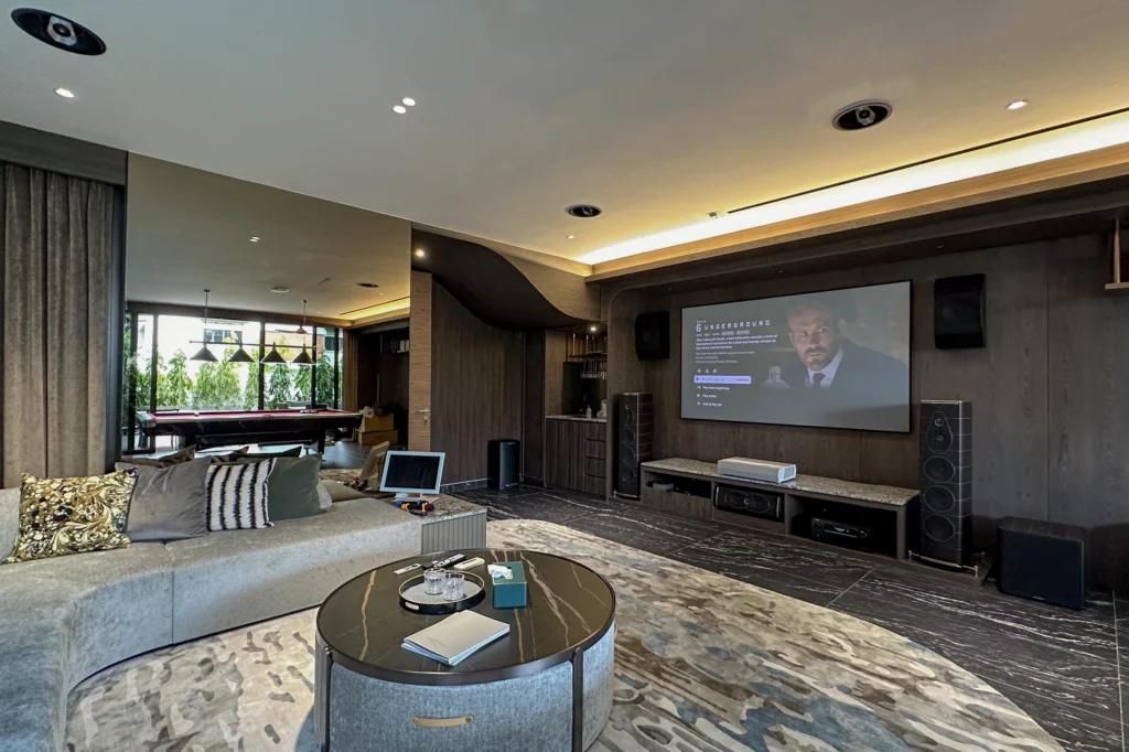Sonus Faber Olympica Nova speakers either side of a large screen in a lounge, with a pool table beyond