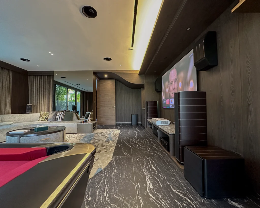 Olympica Nova floorstanding speaker and subwoofer beside the projection screen, with a pool table in the foreground