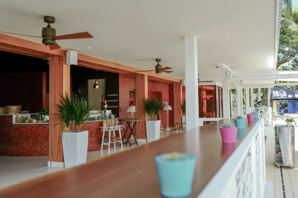 Open-sided counter and walkway at a beachfront restaurant, with a speaker mounted on a white pillar