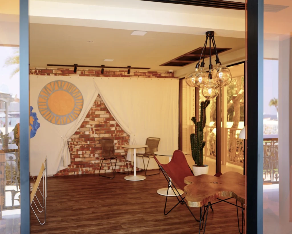 Indoor lounge corner at the restaurant with a brick wall, pendant lights and a leather chair