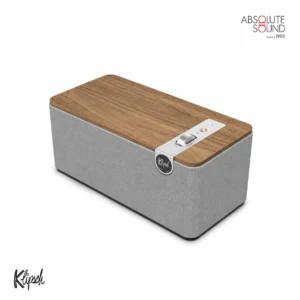Klipsch One Plus tabletop speaker in the walnut finish, with a grey fabric grille and a wood top panel.