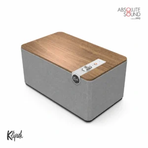 Klipsch Three Plus tabletop speaker with a grey fabric grille and a wood top panel.